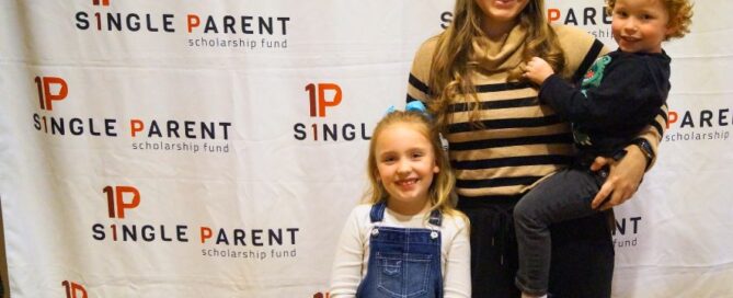 Jocelyn and her two kids stand in front of the ASPSF banner.