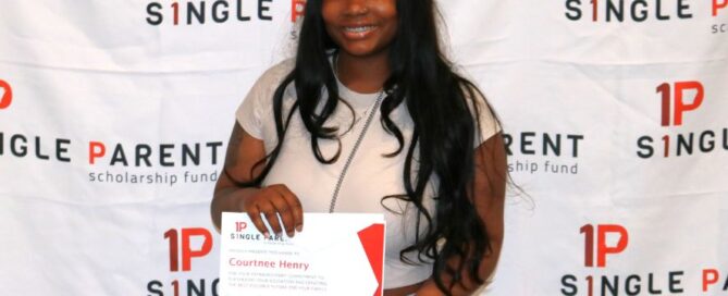 Woman Courtnee receives her single parent scholarship in front of an ASPSF banner.