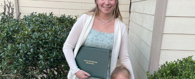 Mom Danielle Frencl holds her degree in one hand and her toddler daughter in another.