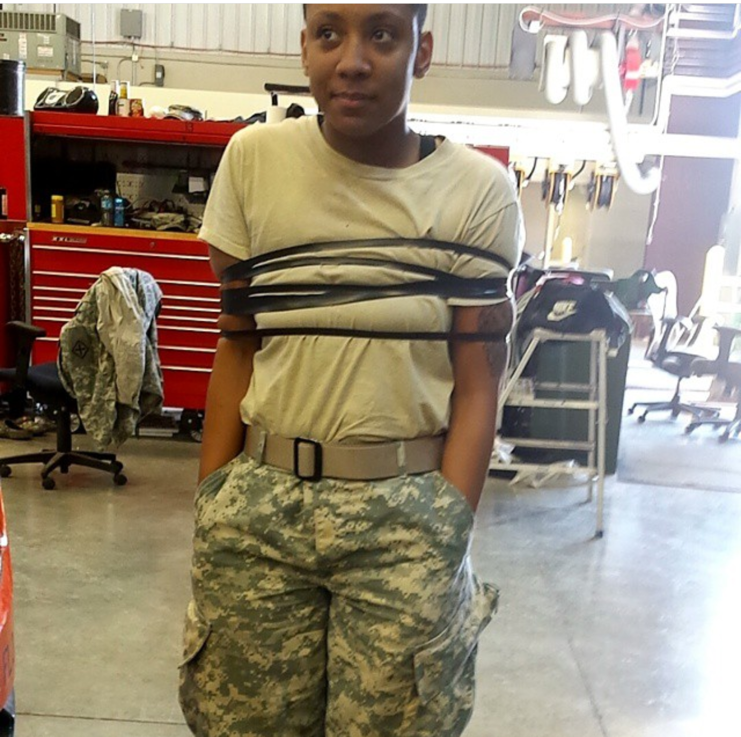 Kristy dressed in camo, wrapped in rope.