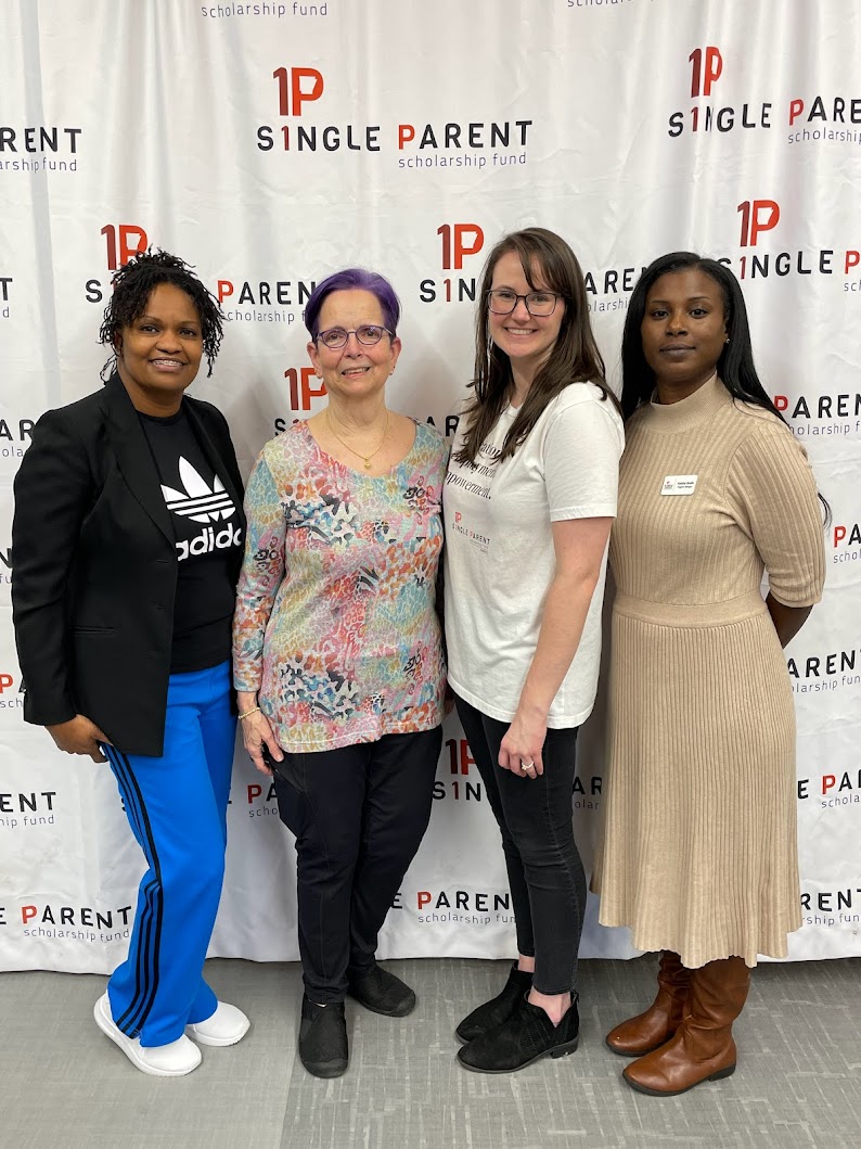Group of women stand in front of ASPSF banner