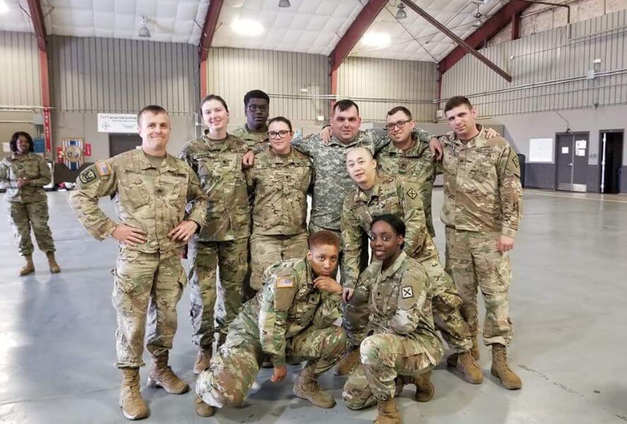 Miltary Service Members pose for photo in their camo.