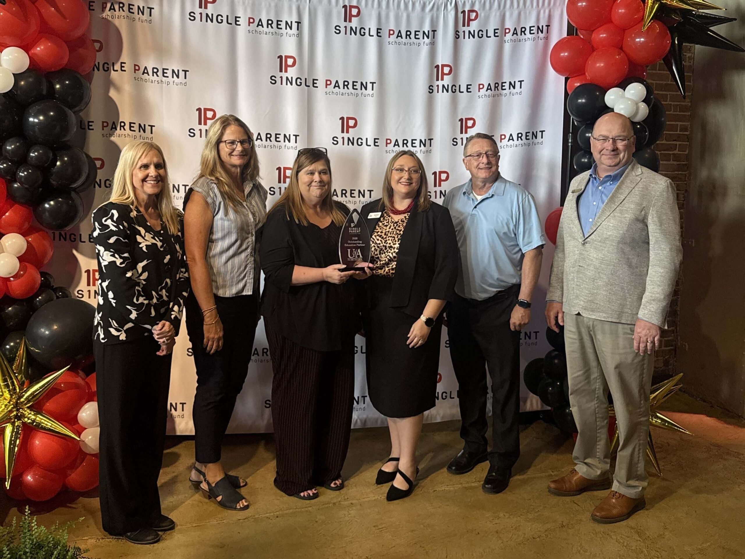 UA Northar-Outstanding Education Partner Members from Northark and Jenn Morehead stand in front of a step-and-repeat.