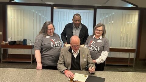 Group of adults watch the maor sign a proclamation